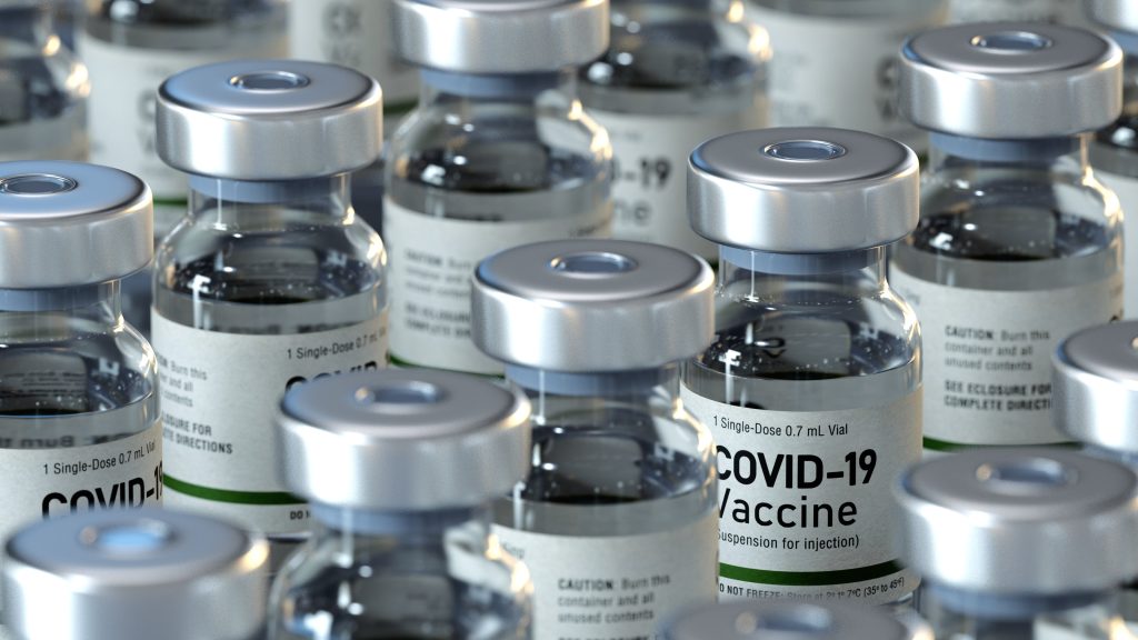 Rows of sealed vaccine vials on a production line